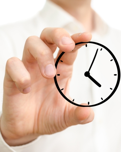 A person holding up a mini cartoon clock in her hand, emphasizing the timely and efficient delivery of a project.